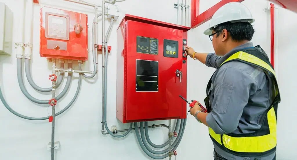 Technician inspecting fire control panel